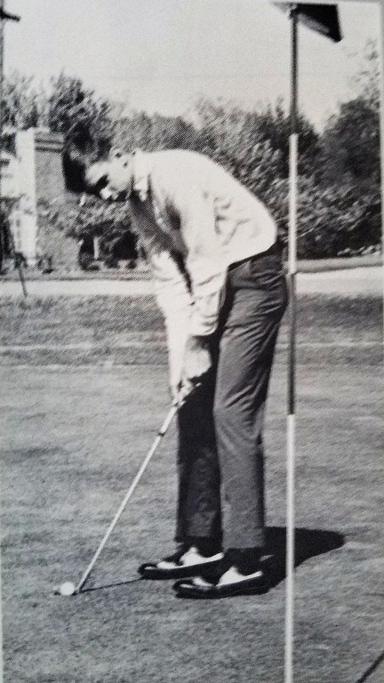 From 1966 Yearbook, Sophomore year.  
Rick Faulk lines up a crucial putt.
(Rick requested a gimme, but was denied. That is the reason for the sour look on his face.)
